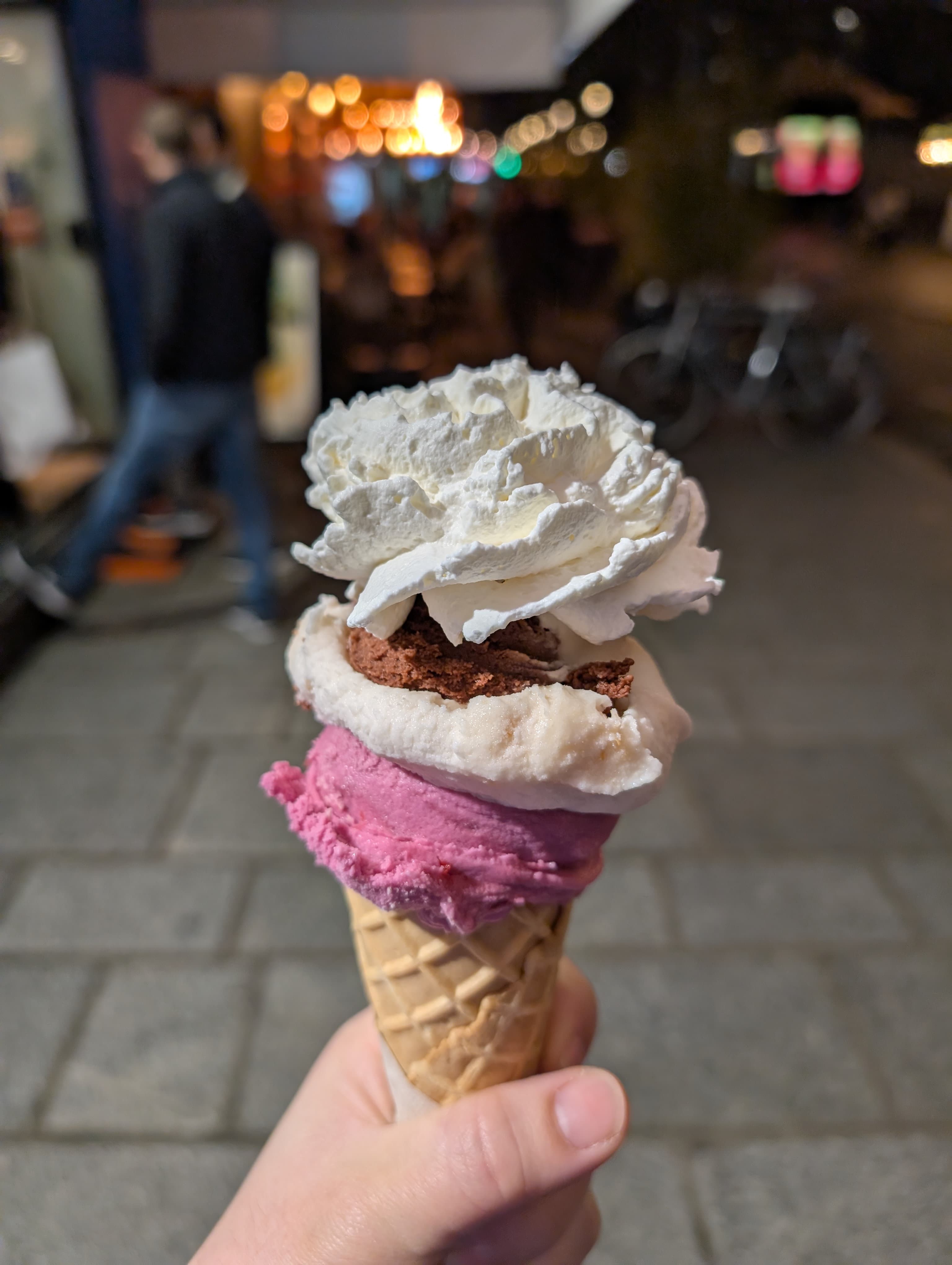 A stacked ice cream cone with whipped cream